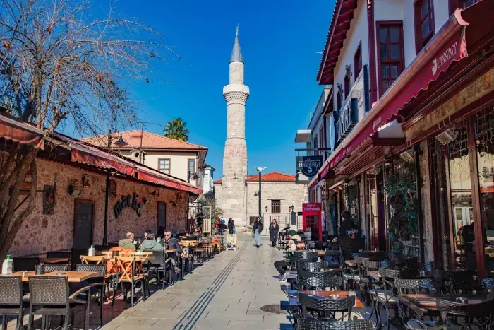 tables of outdoor cafes in old town, minaret Sehzade Korkut Mosque