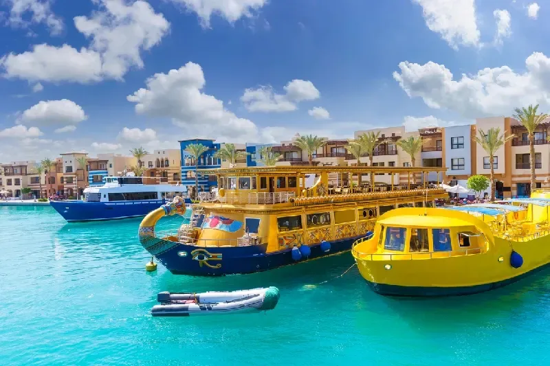 Kleiner tropischer Hafen mit türkisblauem Wasser und ruhigen Booten unter klarem Himmel.