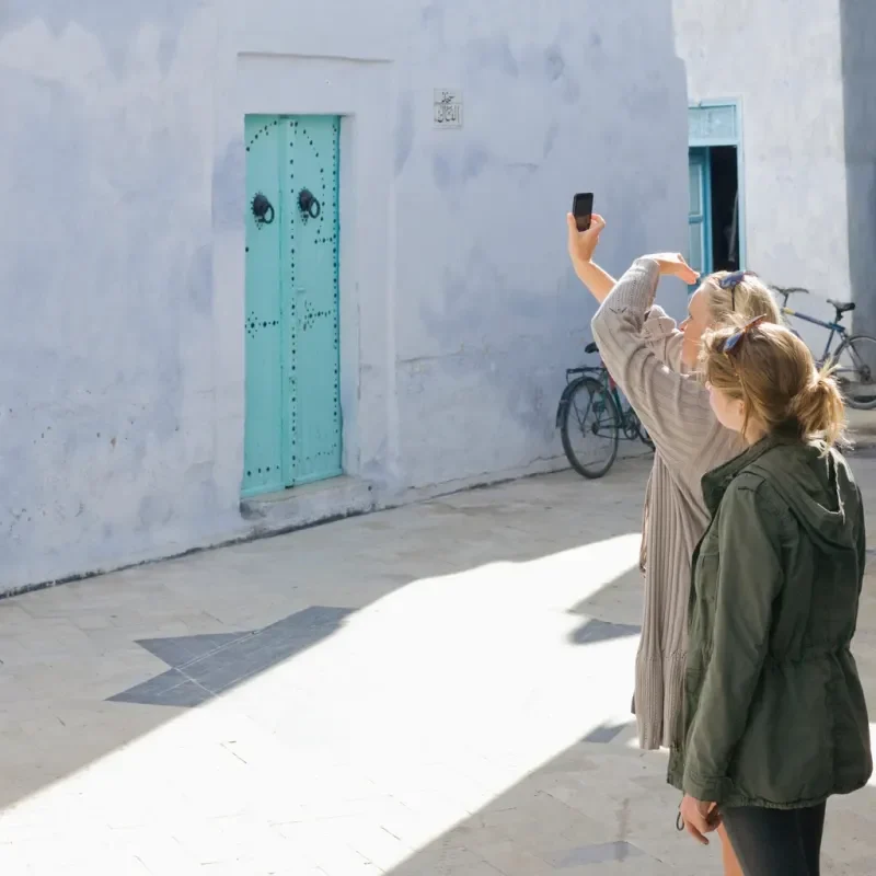 Mother and daughter take photo of old town doorway