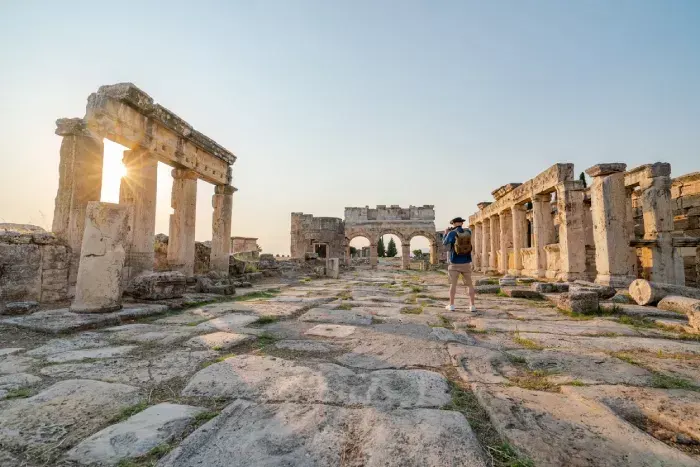 Traveller tourist is taking photo of Frontinus Gate in ancient ruins in Hierapolis , Pamukkale
