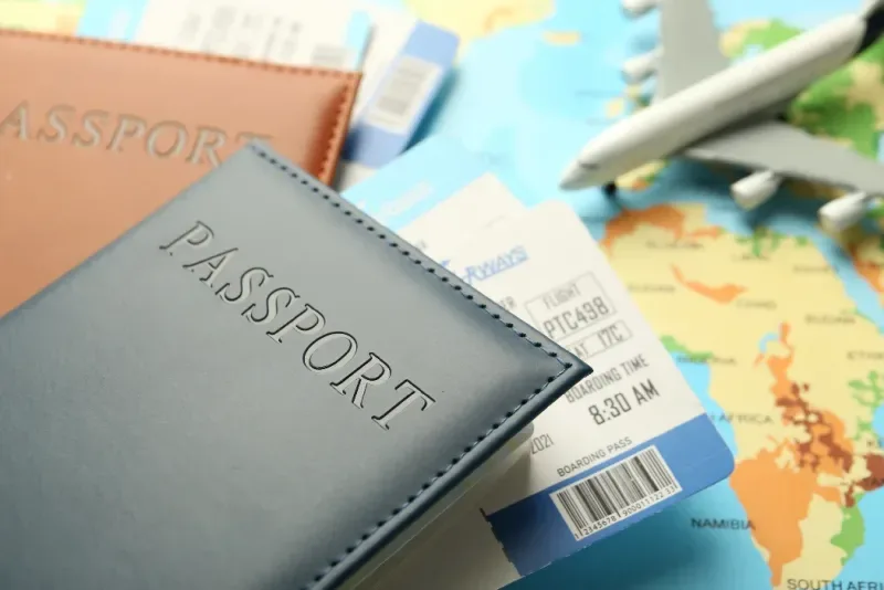 Pasaportes con billetes de avión y una maqueta de avión sobre un mapa del mundo.