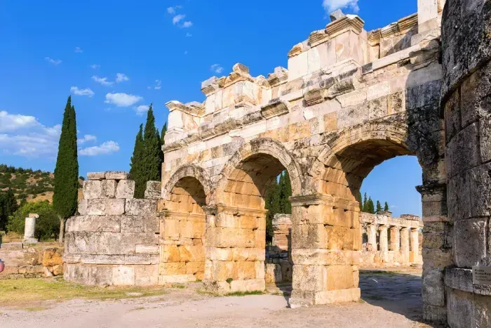 Hierapolis Frontinus Gate against blue sky and green landscape