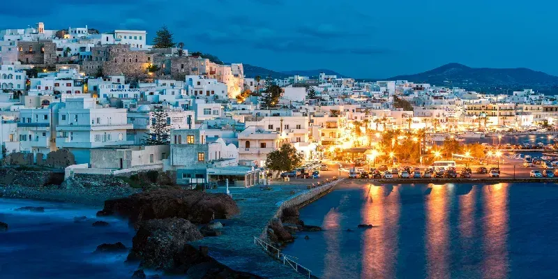 Chora, capital de la isla de Naxos iluminada al anochecer en el mar Egeo, Grecia, Europa.