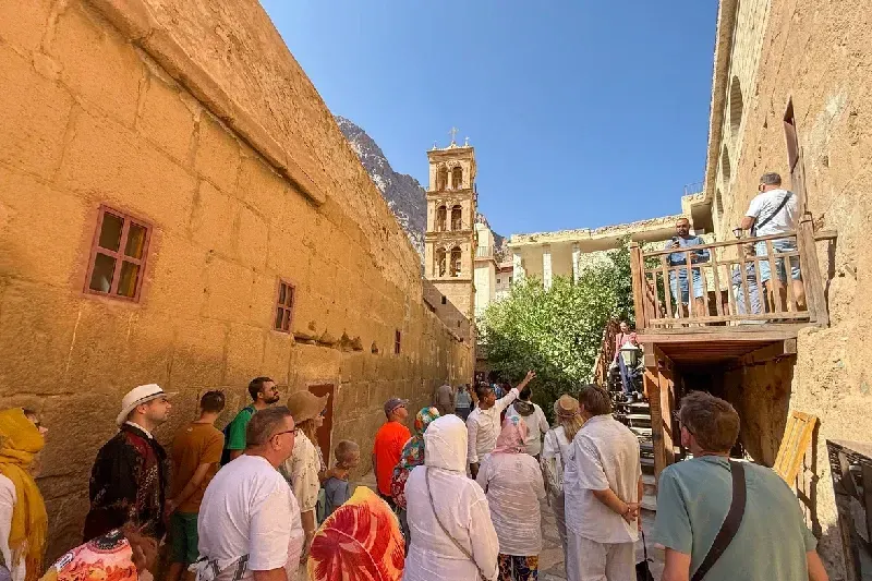 Reiseleiter führt Touristengruppe durch den Klosterhof