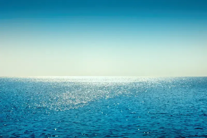 Ein entspannter Tag am Meer mit Wellen, Sandstrand und blauem Himmel.