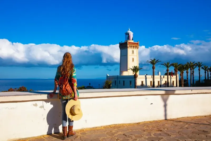 Woman tourist looking at lighthouse of Cap Spartel, Tanger, Morocco