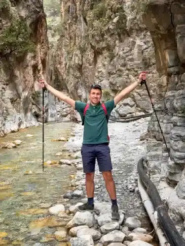 A tourist is taking a photo while hiking in Samaria National Park. Crete Travel Guide