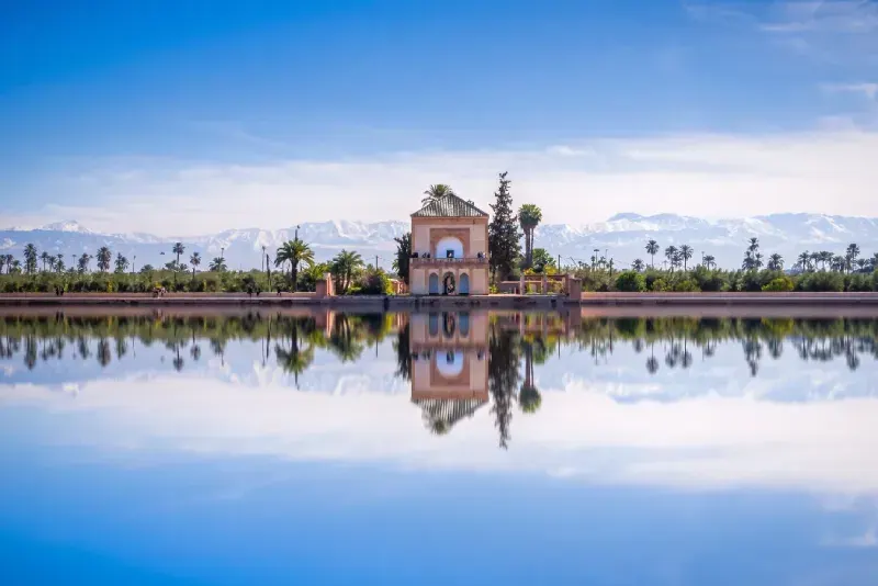 Pabellón saadí, jardines de la Menara y las montañas del Atlas en Marrakech, Marruecos.