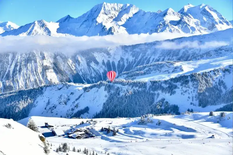 Heißluftballon schwebt über dem Skigebiet Courchevel, Frankreich.