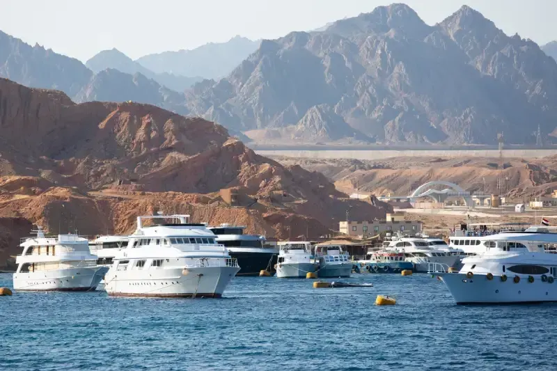 Sharm El Sheikh, Egitto. Yacht bianchi nel porto, deserto e montagne sullo sfondo, estate.