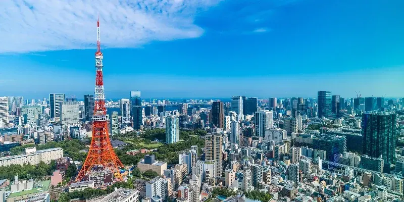 vista aérea de la Torre de Tokio y el horizonte urbano panorámico bajo un cielo azul brillante y sol en Tokio, Japón.