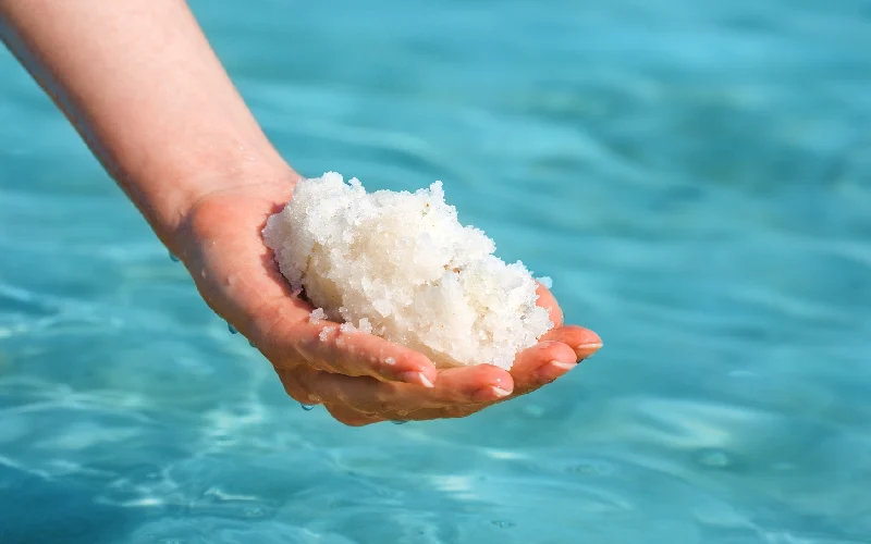 Female hand with sea salt for spa from Dead Sea