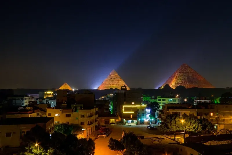 Blick auf die nachts beleuchteten Pyramiden von Gizeh. In Kairo, Ägypten