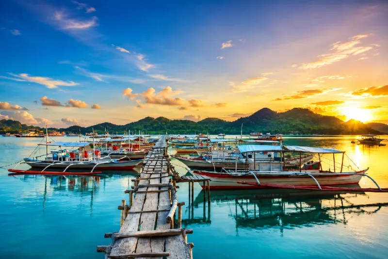 Traditional boats on a tropical island in the Philippines at sunset