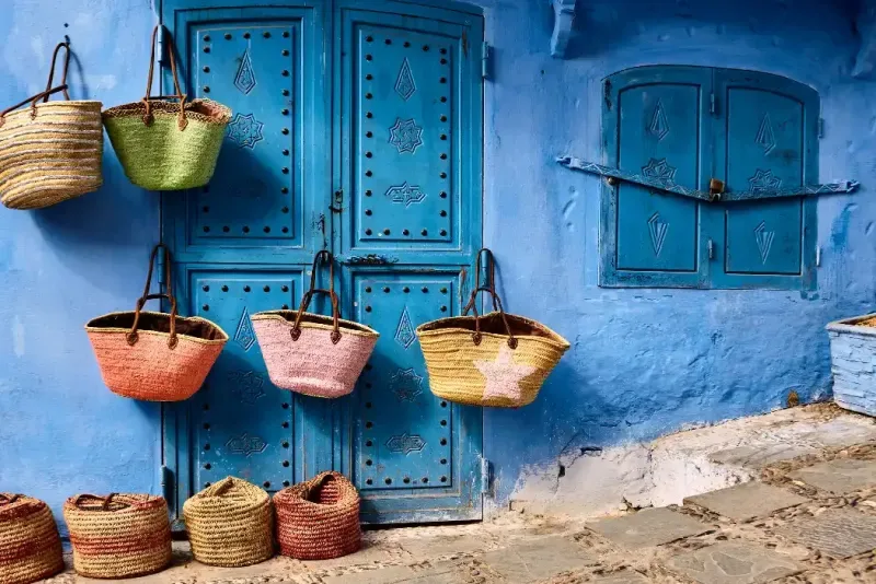 Tienda callejera con coloridas cestas hechas a mano en Chefchaouen, Marruecos, África.