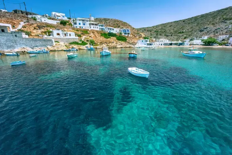 Pintoresco pequeño pueblo de Heronissos, con barcos pesqueros y aguas transparentes, en la isla de Sifnos, Grecia.