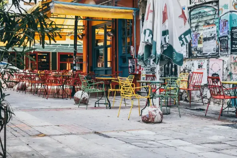 Vista de un bar exterior colorido y acogedor en el barrio de Exarcheia en Atenas