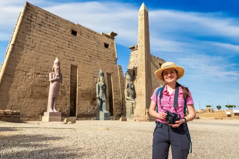 A FemaleTourist with Camera Stand Infront of an Ancient Temple in Luxor