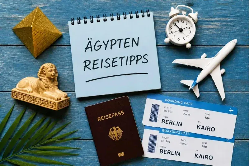 Flatlay auf blauer Holzfläche mit goldener Pyramidenfigur, Sphinx, geöffnetem Notizbuch mit „Ägypten – Reisetipps