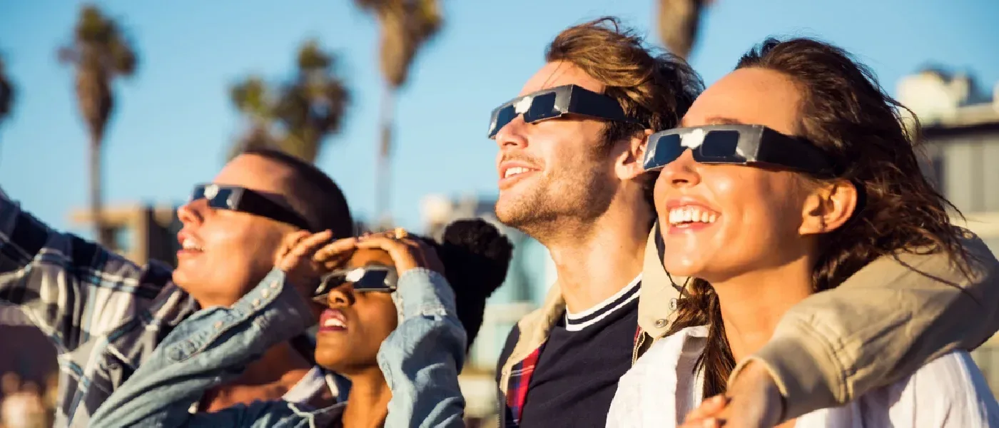 Friends wearing protective eclipse glasses as they prepare to witness the solar eclipse