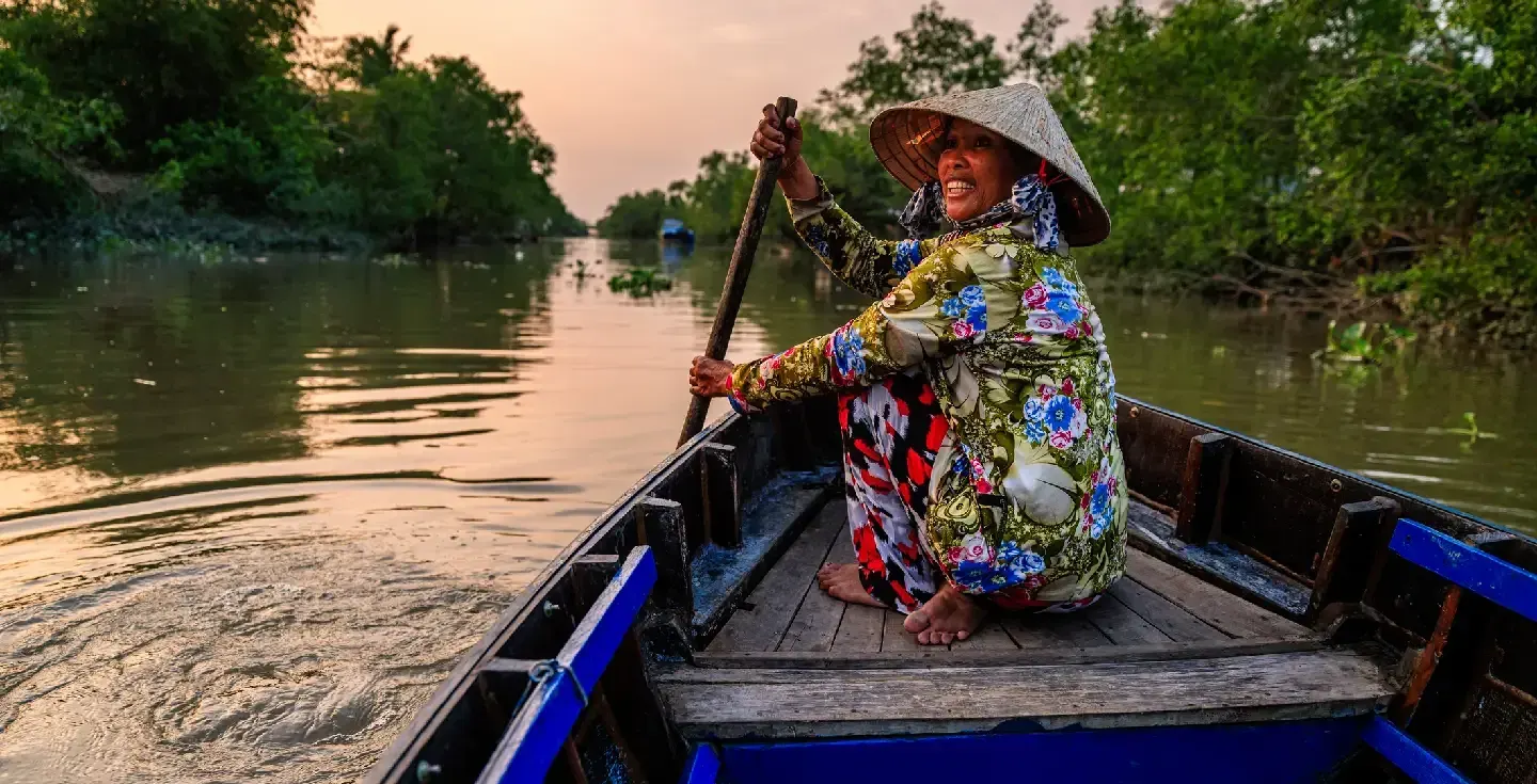 Mujer vietnamita remando en un bote, delta del río Mekong, Vietnam