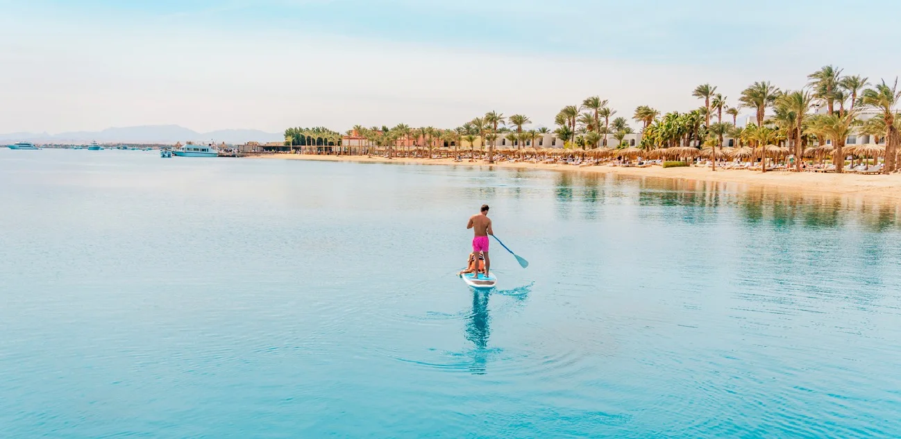 Foto tomada en Hurghada, Egipto: padre con sus hijos en una tabla de paddle surf.