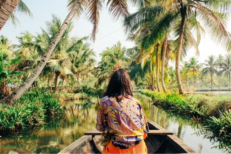 A woman kayaking through the backwaters of Munroe Island.