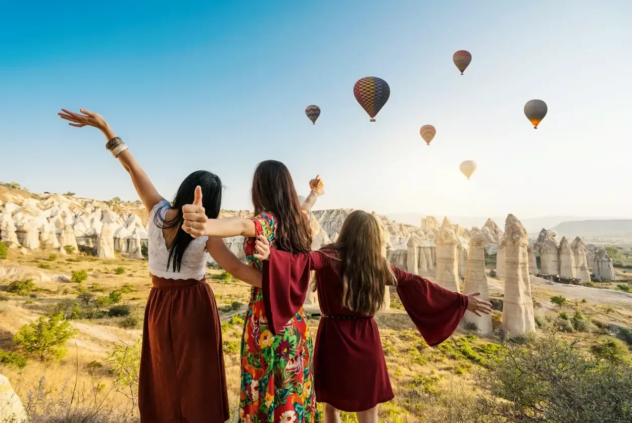3 girls standing in front of hot air balloon in Cappadocia 
