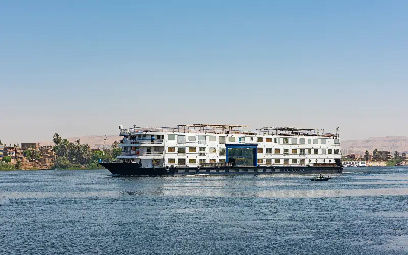 Landscape view across nile river to luxor west bank with cruise boat