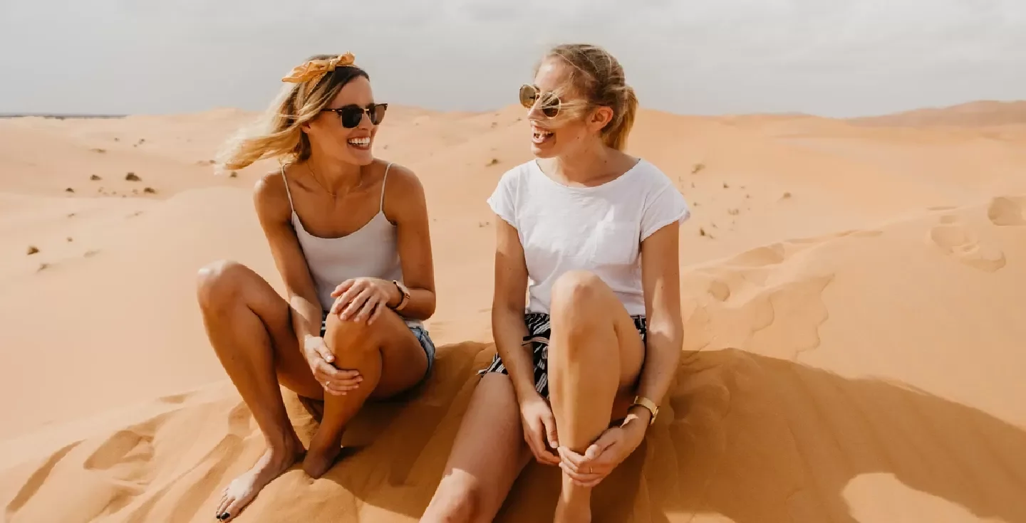 Chicas jóvenes y alegres corriendo en el desierto de Marrakech