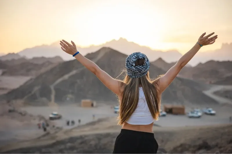 Una bellissima giovane donna bionda corre e si diverte nel deserto durante una vacanza in Egitto.