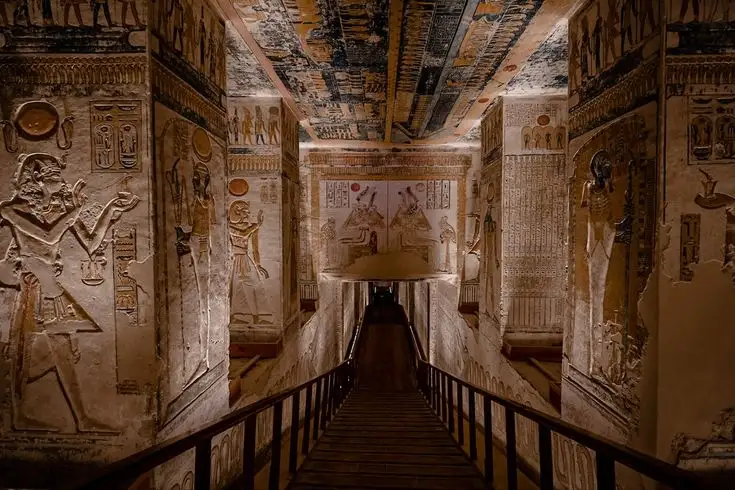 Interior of an ancient Egyptian tomb with colorful wall carvings and hieroglyphs in the Valley of the Kings