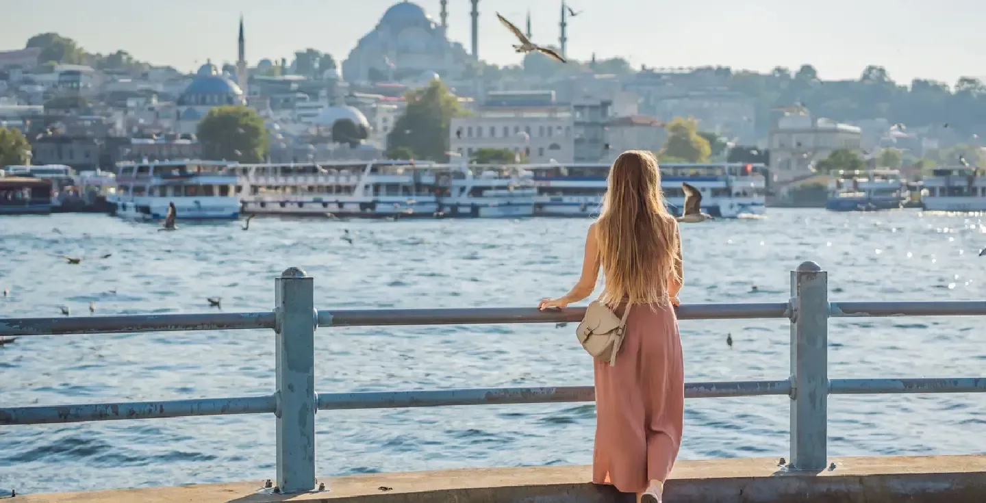 Joven viajera disfrutando de una magnífica vista del Bósforo y de numerosas gaviotas en Estambul.