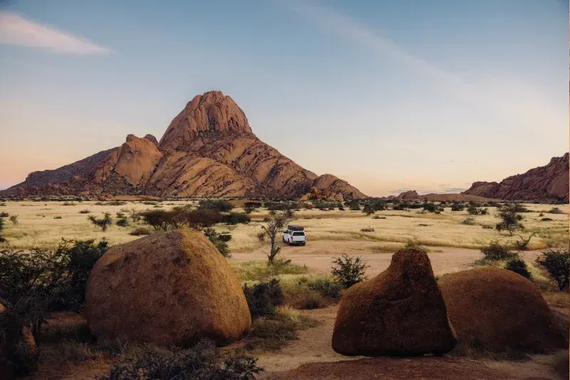 Luftaufnahme eines Campervans in einer dramatischen Wüstenlandschaft bei Spitzkoppe