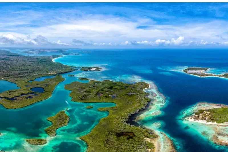 Luftaufnahme von karibischen Cay-Inseln und Küstenlandschaft mit türkisfarbenem Wasser.