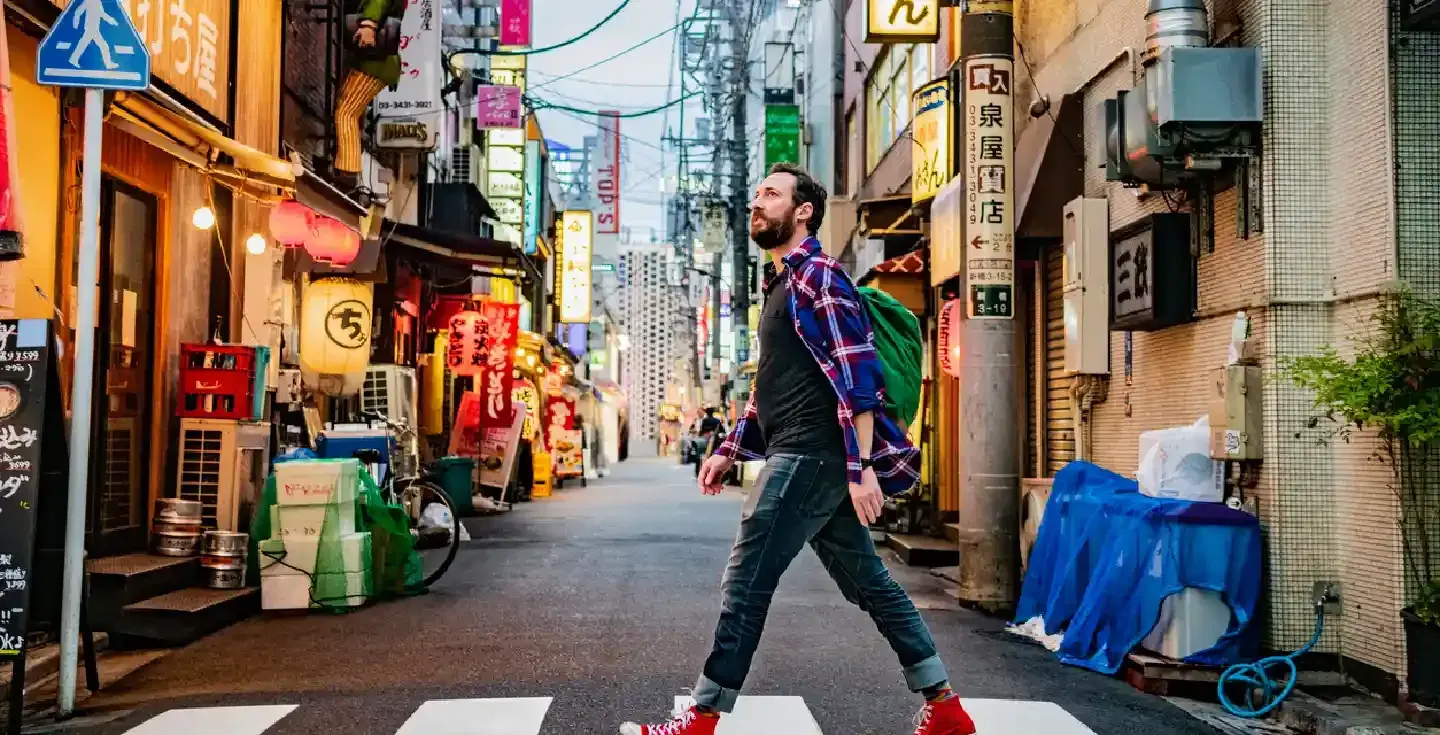 hombre caminando por un paso de peatones en una calle de Tokio
