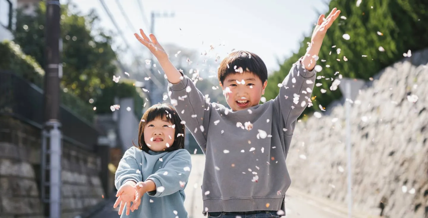 Due bambini giapponese che giocano con i fiori