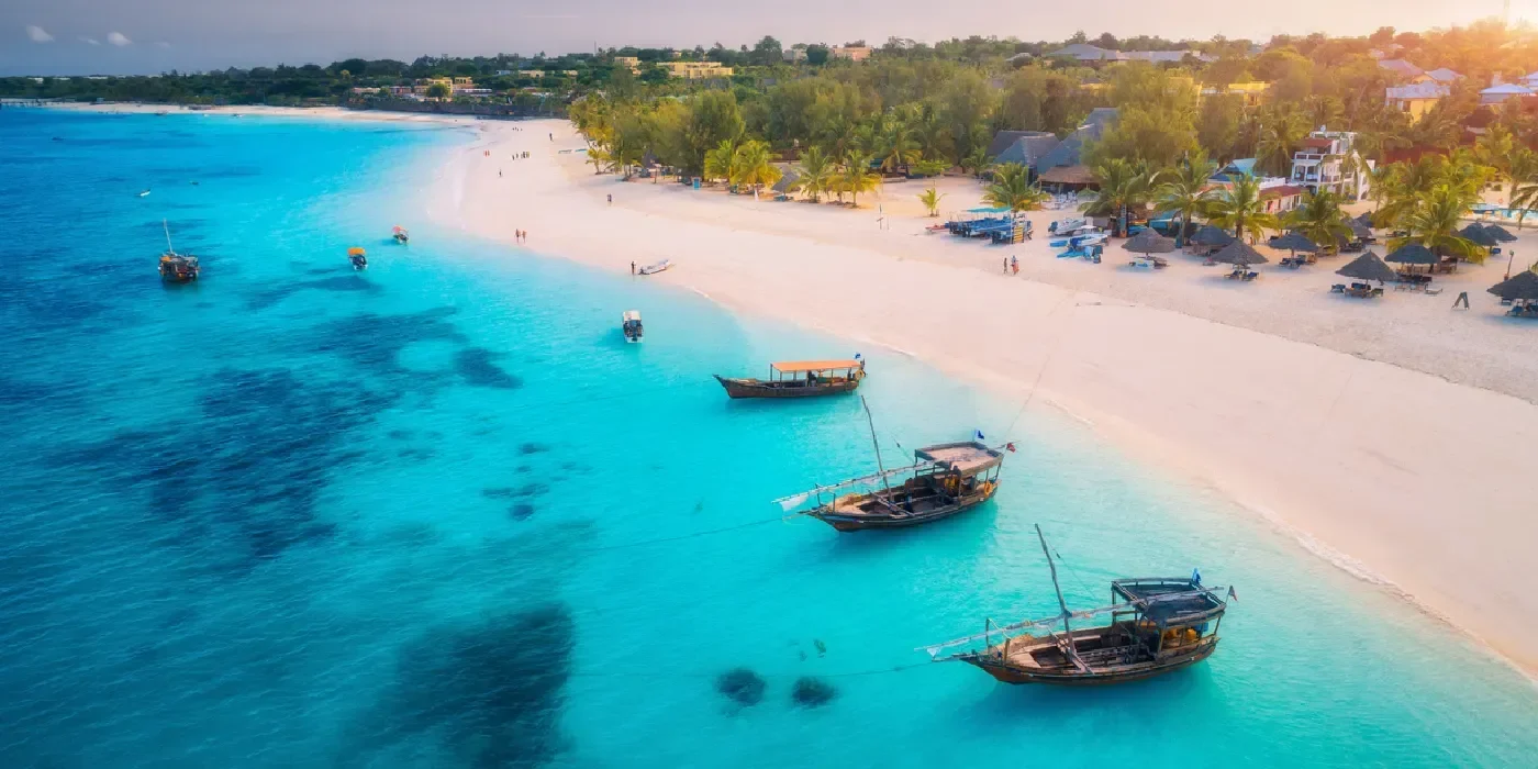Aerial view of a sailboat over Zanzibar’s turquoise waters at sunset
