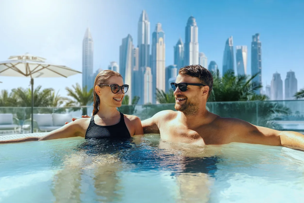 Happy young couple relaxing in outdoor hot tub in Luxury hotel in Dubai