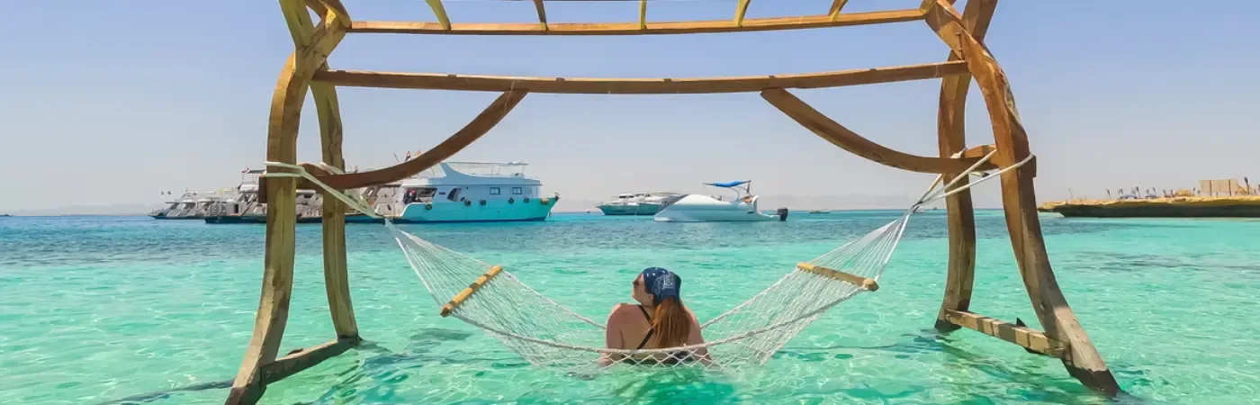 Una splendida giovane donnasi rilassa su un'amaca in spiaggia, in Egitto.