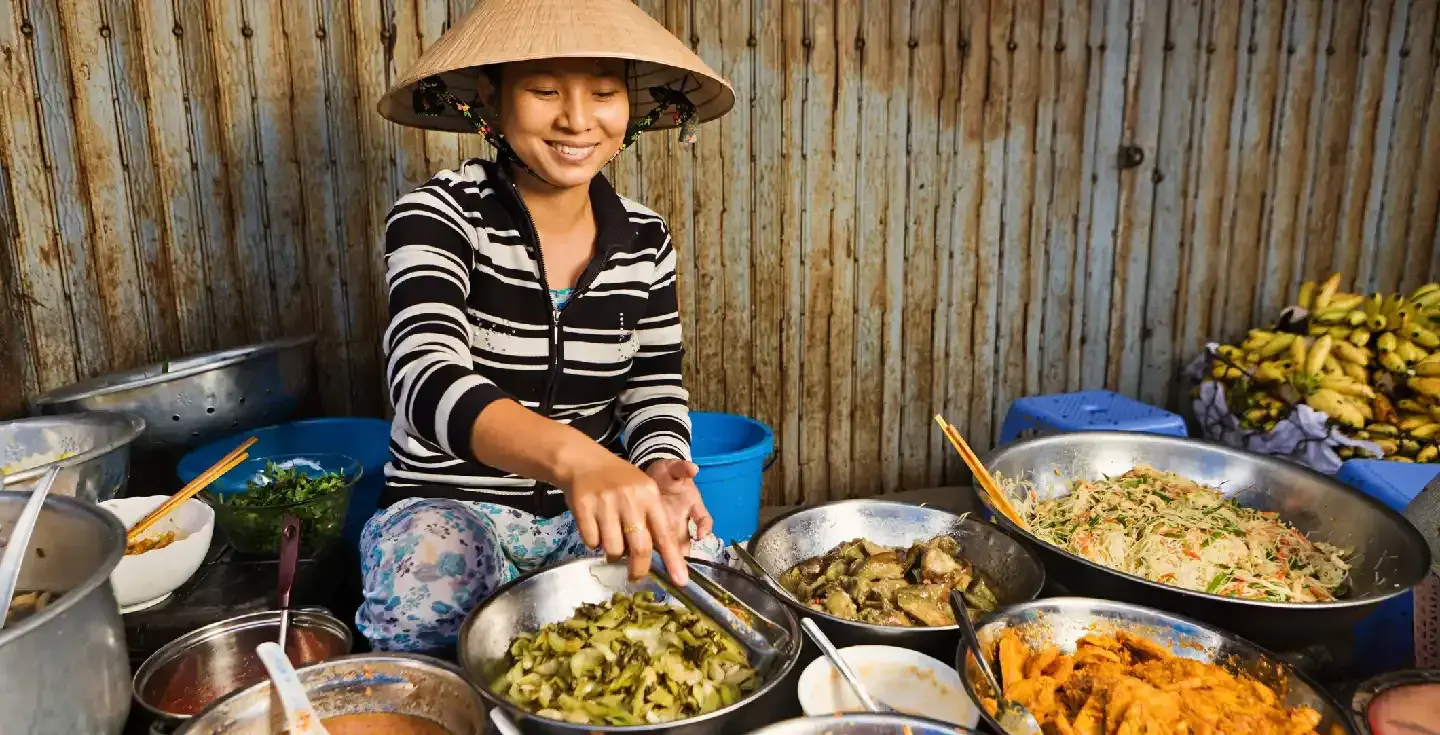Vendedor de comida vietnamita en el mercado local.