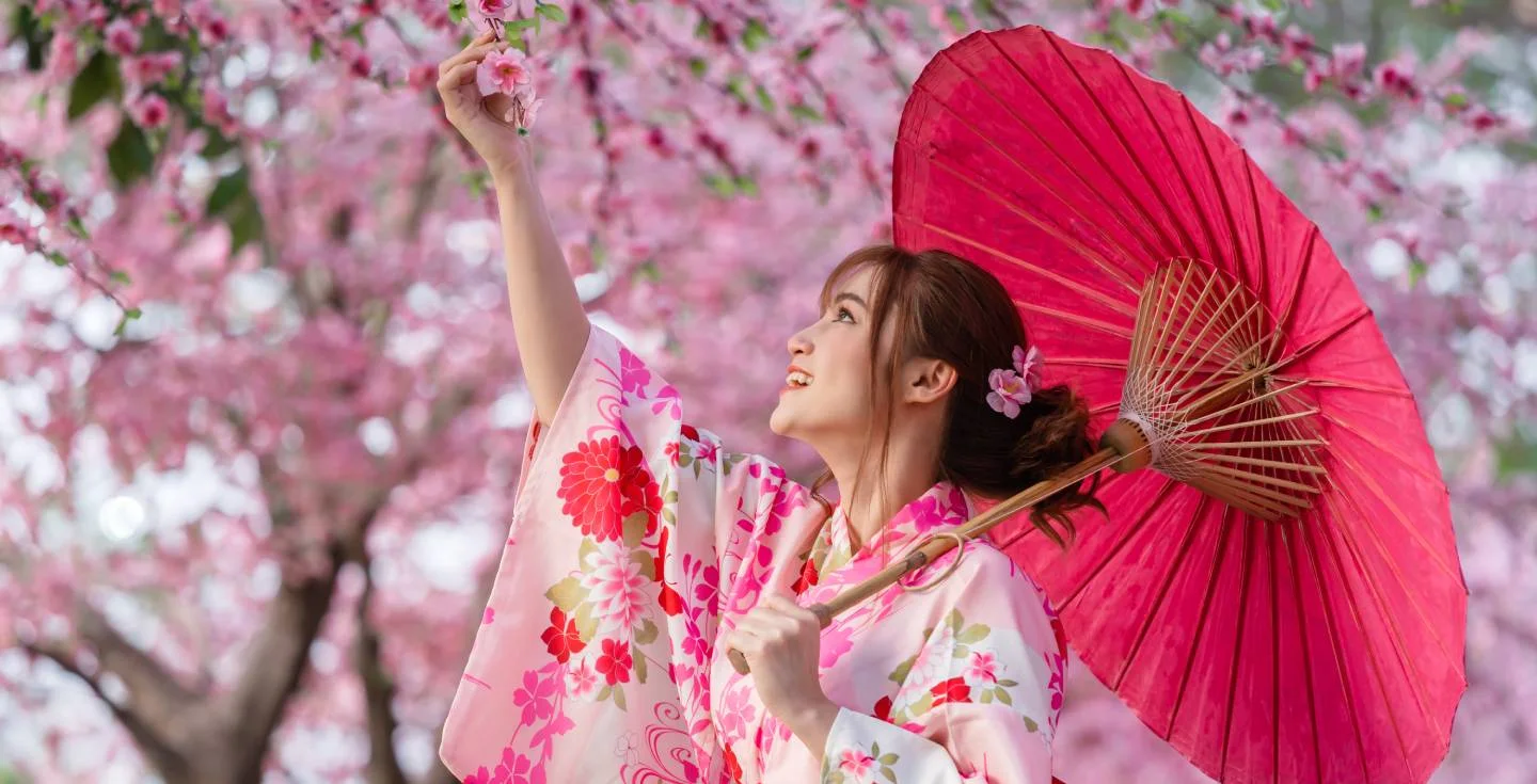 Una giapponese in kimono con fiori di sakura