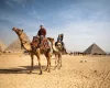 Familia montando camellos en las pirámides de Guiza