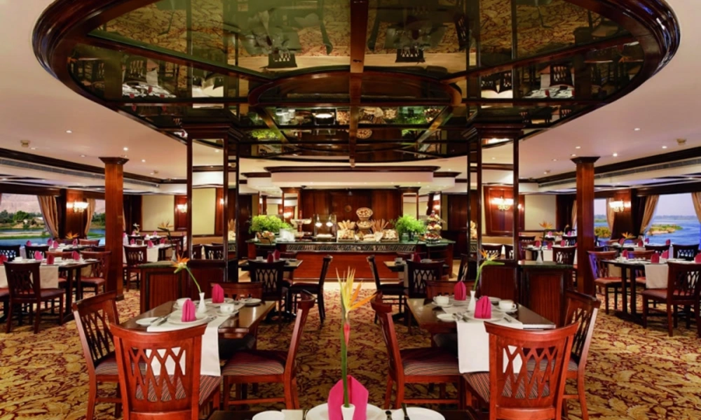 Restaurant an Bord der H.S. Radamis mit eingedeckten Tischen und offener Galerie