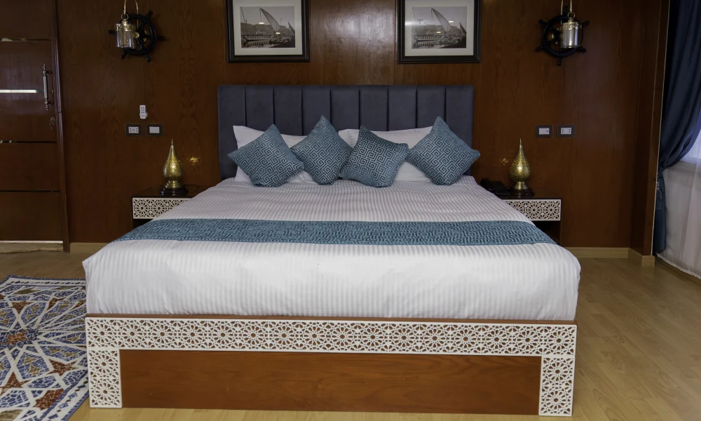 Doppelbett in einer Suite der Dahabeya Queen Isis mit Holzvertäfelung