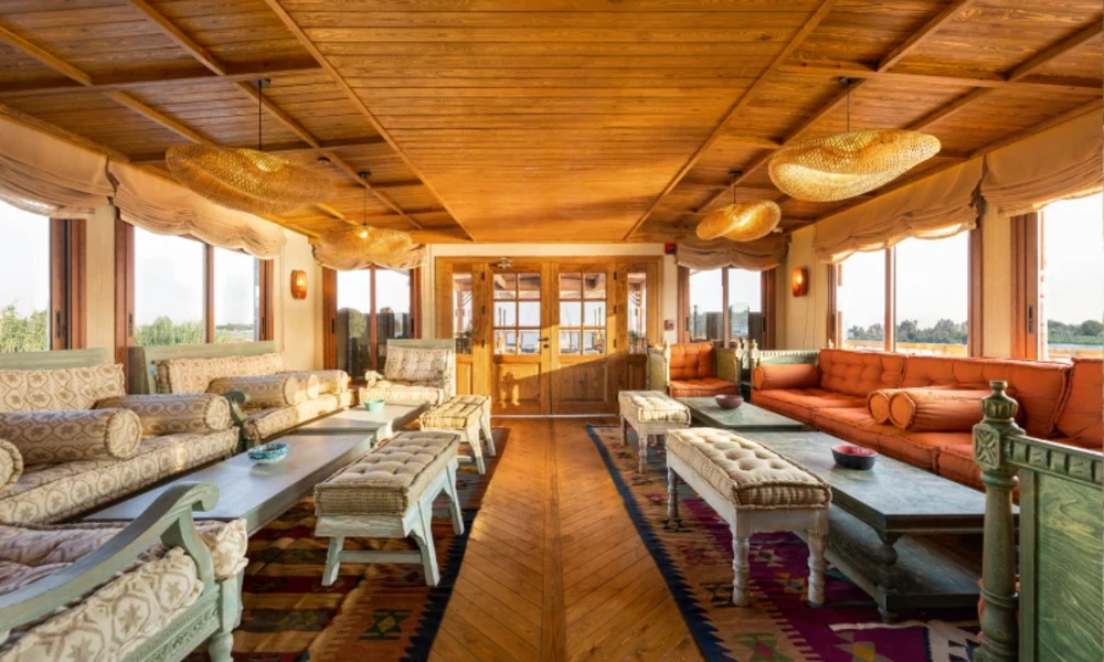 Gemütliche Lounge mit Sofas und Nilblick an Bord der Nonia Dahabiyya