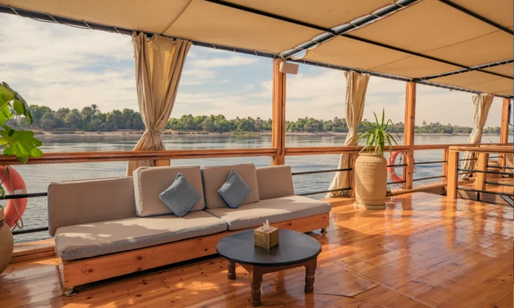 Offenes Sonnendeck mit Sofa und Blick auf den Nil an Bord der Nuut & Nuun Dahabiyya