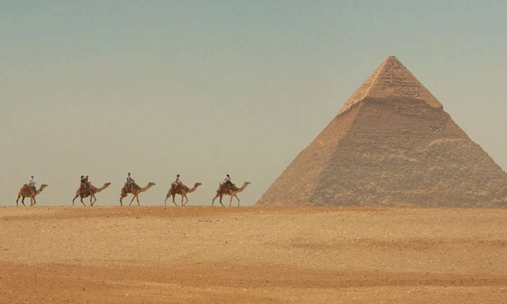 Kamelkarawane vor einer Pyramide von Gizeh bei Kairo