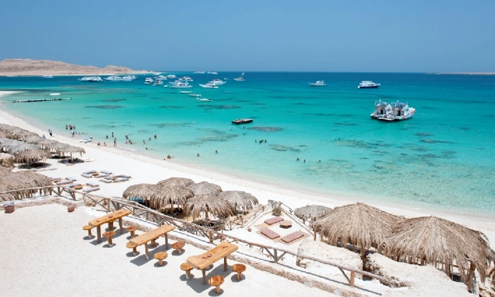 Luftaufnahme eines weißen Sandstrands mit Booten und türkisem Wasser