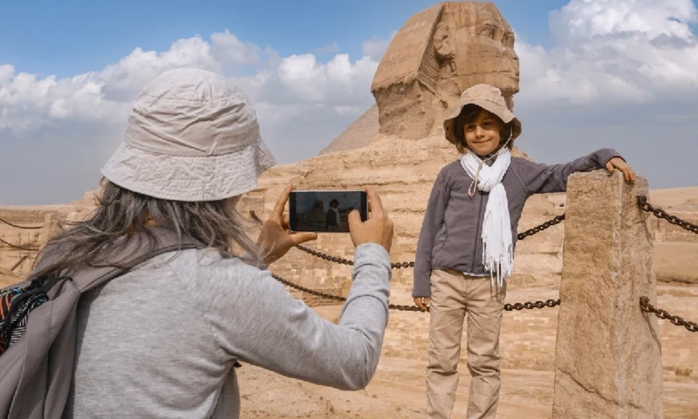 Kind wird vor der Großen Sphinx von Gizeh fotografiert